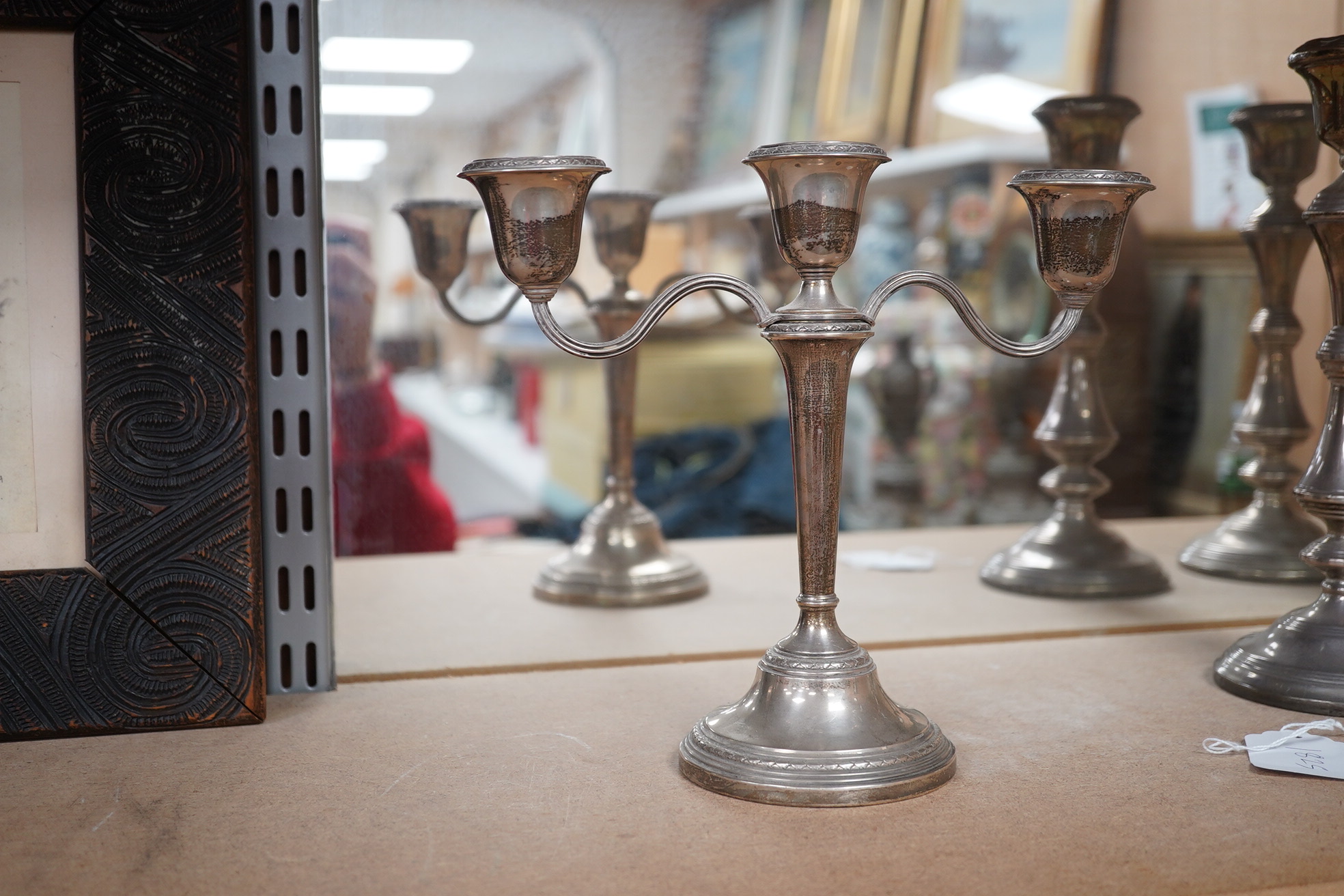 A pair of Elizabeth II silver candlesticks, Broadway & Co, Birmingham, 1960, 25.7cm, weighted, together with a similar silver three light candelabrum, by Adie Bros, weighted. Condition - poor to fair